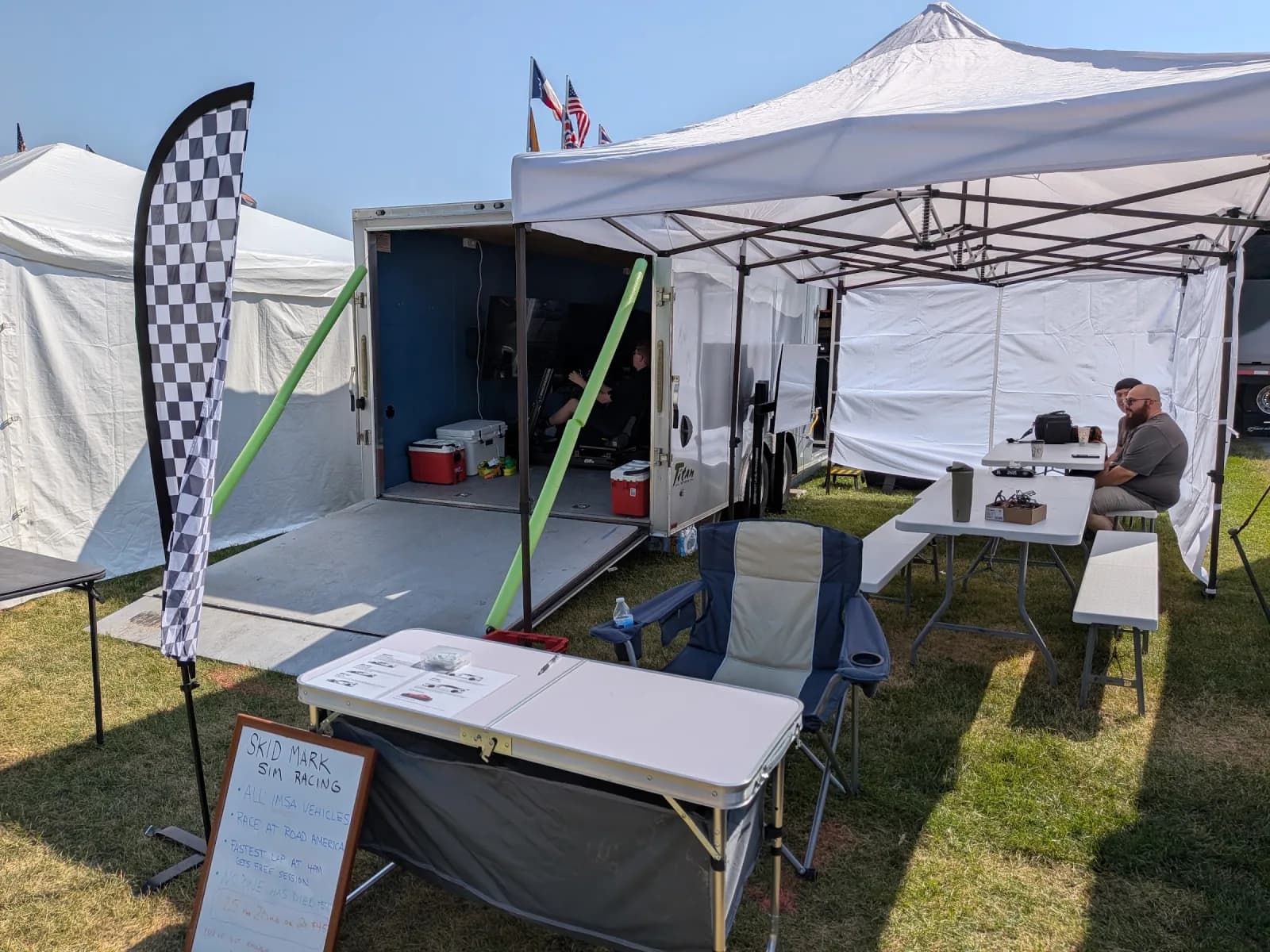 Skid Mark trailer and tent with a check-in table arranged for an outdoor event
