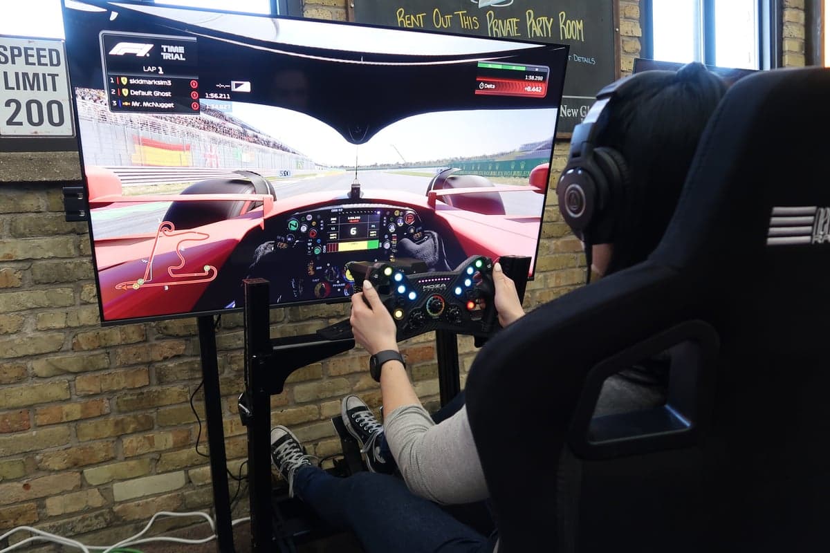 Guests gathered around a Skid Mark simulator at a hosted group event